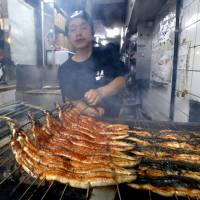 Whetting appetites: An employee at Osaka\'s Funaya grills eel on the Day of the Ox on July 25. | KYODO