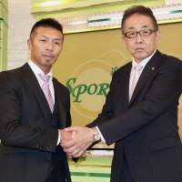 Former WBA super flyweight champion Takashi Uchiyama shakes hands with his gym president Hitoshi Watanabe on Saturday. The veteran boxer announced his retirement on the same day. | KAZ NAGATSUKA