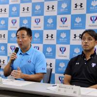 Dome Corporation CEO Shuichi Yasuda, who will be the leader of the University of Tsukuba\'s athletic department formation task force, speaks to the media while university officials Yukio Yamada (left) and Tsuyoshi Matsumoto look on Thursday at the school\'s Tokyo campus. | KAZ NAGATSUKA