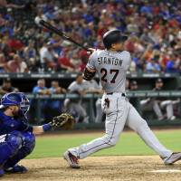 Miami’s Giancarlo Stanton watches his second home run against Texas on Monday night leave the yard in the eighth inning. Stanton stays hot, powers Marlins past Rangers