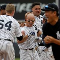 Brett Gardner is congratulated by his Yankees teammates after his walk-off single on Saturday in New York’s 5-4 victory over the Rays. Gardner records game-winning hit for Yanks