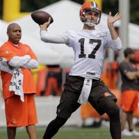 Cleveland Browns QB Brock Osweiler throws a pass on Thursday as coach Hue Jackson looks on during training camp in Berea, Ohio. 'Pacman' accepts ban, gets emotional