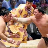 Yokozuna Hakuho (right) defeats sekiwake Tamawashi for the 1,047th victory of his career on Thursday at the Nagoya Grand Sumo Tournament, tying Kaio\'s all-time record. | KYODO