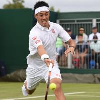 Kei Nishikori plays a shot from Italy’s Marco Cecchinato in their first-round match at Wimbledon on Monday. Nishikori won 6-2, 6-2, 6-0. Nishikori routs Cecchinato, aims to win title