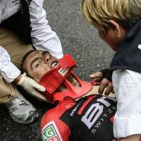 Richie Porte receives medical attention after crashing during the Tour de France. Brutal stage takes toll at Tour