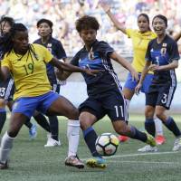 Brazil’s Ludmila (left) is challenged by Japan’s Mina Tanaka in the first half of a Tournament of Nations match on Thursday in Seattle. Brazil women earn tie against Japan with late goal in Tournament of Nations opener