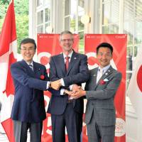 Canadian Ambassador Ian Burney (center) poses with Nobuteru Ishihara (left), minister in charge of economic revitalization, and Kiyoshi Odawara, parliamentary vice-minister of foreign affairs, during a reception to mark Canada Day in Tokyo on June 30. | YOSHIAKI MIURA