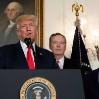 U.S. President Donald Trump, flanked by (from left) Treasury Secretary Steven Mnuchin, U.S. Trade Representative Robert Lighthizer and Commerce Secretary Wilbur Ross, delivers remarks before signing a memorandum directing the U.S. Trade Representative to complete a review of trade issues with China at the White House in Washington Monday. Trump orders inquiry into whether to probe China for intellectual property theft
