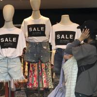 A shopper chooses clothes at a store in Tokyo’s Omotesando shopping district. Japan’s economy gained momentum in the April-June quarter thanks to stronger consumer spending, but economists are split over whether the trend will continue. Japan's economy revs up, but analysts remain skeptical whether robust spending will last