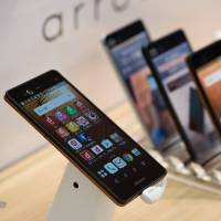 Fujitsu Ltd. Arrows NX smartphones are seen on display at an NTT Docomo Inc. store in Tokyo. The electronics manufacturer is reportedly considering selling its mobile phone business after struggling in the market. Fujitsu looks to sell struggling mobile phone business