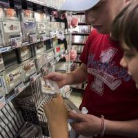 French tourists shop for video game titles for the Super Nintendo Entertainment System (SNES) console at the Super Potato video game store in Akihabara, Tokyo, on Aug. 8. Blasts from the past: Japan's gaming classics get a retro revival