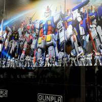 A woman shoots video during a media preview of Gundam Base Tokyo on Thursday in Tokyo’s Odaiba waterfront district. Japan's first Gundam Base to woo model-building fans in Odaiba
