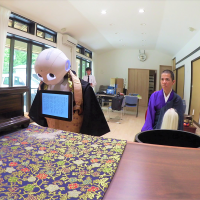 Pepper, the robot created by SoftBank Robotics, bows during a Buddhist ritual with a monk at a temple in Yokohama on July 20. Nissei Eco Co. has programmed Pepper to recite sutras as part of its expanded funeral service business. Pepper the robot to don Buddhist robe for its new funeral services role