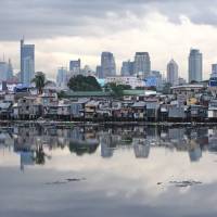 Manila’s skyline is reflected on a river showing both residential and business districts in the Philippines. Philippines courts Japan, China to invest in $135 billion power project