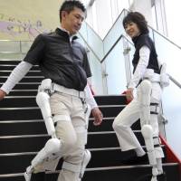 Robotic suits named HAL (Hybrid Assistive Limb) are demonstrated during a news conference at the headquarters of Cyberdyne in Tokyo on Oct. 7, 2008. Labor-short Japan embraces robot takeover