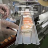 Wrapped pieces of sushi exit a Suzumo Machinery Co. machine during a demonstration at its factory in Kawashima, Saitama Prefecture, on Aug. 7. Suzumo Machinery’s robots are used by about 70,000 customers around the world, ranging from sushi chains to factories, and account for about 70 percent of the market for the equipment at restaurants, according to Suzumo’s estimates. How a rice lover's robot revolutionized the modern sushi industry