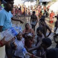 Flood-affected villagers collect drinking water and relief food at Alal village in Malda district in the Indian state of West Bengal on Wednesday. Two-week death toll from South Asia flooding tops 1,000