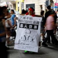 A protester covers his eyes with red ribbon to call for the release of Liu Xia, the wife of late Chinese Nobel Peace Prize laureate Liu Xiaobo, in Hong Kong on Wednesday. The sign reads: “Missing person. Please help to find Liu Xia.” Chinese Nobel laureate Liu Xiaobo's widow makes first appearance since funeral