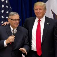 Then-Republican presidential candidate Donald Trump is joined by then-Maricopa County, Arizona, Sheriff Joe Arpaio at a campaign event in Marshalltown, Iowa, in 2016. Arpaio says he isn’t asking President Donald Trump to issue a pardon for his misdemeanor conviction last week for defying a judge’s order to stop his immigration patrols, even though he endorsed Trump and shared the stage with him at several rallies during the 2016 campaign. The former six-term sheriff of metro Phoenix said he doesn’t expect anything in return for his support of Trump and that he doesn’t feel abandoned by the president. Critics cry racism as Trump weighs Arpaio pardon on heels of tardy rebuke of white supremacists