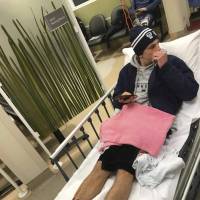 With his ankles and feet covered in blood, teenager Sam Kanizay is seen on a bed in the waiting room at Sandringham Hospital in Melbourne, Australia, on Saturday. Aussie teen soaks feet in sea, finds mystery creatures chewed them up