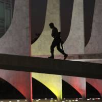 A soldier walks up the ramp of Brazil’s Planalto Presidential Palace, illuminated with the colors of Spain in honor of the victims of the Barcelona attack, at dawn in Brasilia on Friday. Botched explosion prevented worse carnage in attacks on tourists in Spain