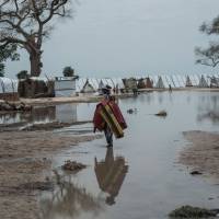 A woman stands in a pool of rain water in Rann in northeast of Nigeria close to the Cameroonian border on Saturday. Thousands flee Niger for Chad in fear of Boko Haram