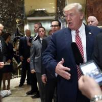 President Donald Trump speaks to reporters in the lobby of Trump Tower on Tuesday in New York. At left with his hands clasped is White House chief of staff John Kelly. As Trump loses CEO support, business leaders face tough choice of giving up tax reform hopes