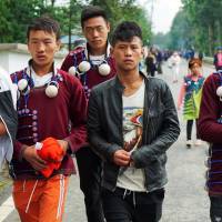 Yi boys walk toward the valley where traditional games for the Torch Festival are held in Butuo County, Sichuan province, China, on July 22. | REUTERS