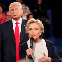 Then-Republican U.S. presidential nominee Donald Trump listens as Democratic nominee Hillary Clinton answers a question from the audience during their presidential town hall debate at Washington University in St. Louis last Oct. 9. Clinton: My 'skin crawled' as Trump hovered on debate stage