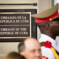 A member of the Cuban honor guard stands next to a new plaque at the front door of the newly reopened Cuban Embassy in Washington July 20. The State Department has expelled two diplomats from Cuba’s Embassy in Washington following a series of unexplained incidents in Cuba that left U.S. officials there with physical symptoms. U.S. diplomats' hearing loss in Cuba blamed on covert sonic device