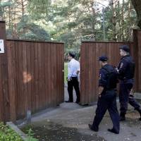Russian police  enter a territory of a dacha compound used by U.S. diplomats for recreation, in Serebryany Bor residential area in the west of Moscow Monday. | REUTERS