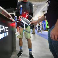 An vendor shows off a small drone during a show for retailers in Salt Lake City on July 29. | BLOOMBERG