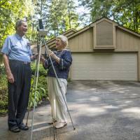 In this photo provided by Clemson University, Donald and Norma Liebenberg stand in the driveway of their home in Salem, South Carolina, on Thursday. Donald has seen and blogged about his 26 eclipses for Clemson University where he does research, and holds the record for most time in totality because the retired federal scientist used to chase them by airplane whenever possible. But in 2017, the celestial event will come to him. Chasing eclipses to the ends of the Earth a way of life for some