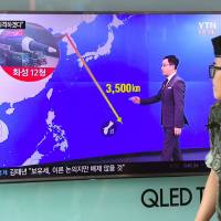 A South Korean soldier walks past a television screen showing a graphic of the distance between North Korea and Guam at a railway station in Seoul on Wednesday. President Donald Trump issued an apocalyptic warning to North Korea on Tuesday, saying it faces “fire and fury” over its missile program, after US media reported Pyongyang has successfully miniaturized a nuclear warhead. Guam residents used to Pyongyang's threats find latest salvo unsettling, lack confidence in Washington