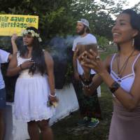 Eva Aguon Cruz holds a cup with burned flower in a ritual calling on the spirits for protection at a peace rally in Hagatna, Guam, on Monday. North Korean nuclear threat renews push on Guam to achieve statehood — or independence