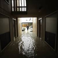 A man searches for people to help in an apartment complex as floodwaters from Tropical Storm Harvey rose Tuesday in Kingwood, Texas. Washington may fail to heed Harvey climate warning, experts say