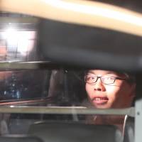 Student leader Joshua Wong leaves the Hong Kong High Court in a prison van after his sentencing on charges related to the 2014 pro-democracy “Umbrella Movement” on Thursday. Critics cry foul as Joshua Wong and other young Hong Kong democracy leaders get jail