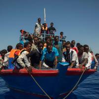 Migrants wait to be rescued by the Aquarius rescue ship run by nongovernmental organisations (NGO) SOS Mediterranee and Medecins Sans Frontieres (Doctors Without Borders) in the Mediterranean Sea, 30 nautical miles from the Libyan coast, on Wednesday. Italy began enforcing a controversial code of conduct for charity boats rescuing migrants in the Mediterranean as new figures revealed a sharp drop in the numbers of people arriving from Libya. Italy begins naval mission in Libyan waters to curb migrant flows
