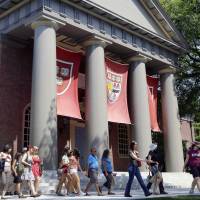A tour group walks through the campus of Harvard University in Cambridge, Massachusetts, in 2012. Word of an August Justice Department inquiry into how race factors into admissions at Harvard University has left top-tier colleges bracing for scrutiny of practices that have boosted diversity levels to new highs. While they keep their selection formulas under wraps, Ivy League colleges defend race-conscious approaches that contributed to a 17 percent increase in nonwhite students over a recent five-year span. Ivy League schools brace for Justice Department scrutiny of race in admissions