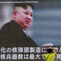 A man takes a photo of a TV news program in Tokyo showing an image of North Korean leader Kim Jong Un Wednesday. In an exchange of threats, U.S. President Donald Trump warned Pyongyang of \"fire and fury like the world has never seen\" and the North\'s military claimed Wednesday it was examining plans for attacking Guam. | AP