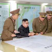 North Korean leader Kim Jong Un reviews the plan for landing missiles near the U.S. territory of Guam in this undated still photo taken from video provided by KRT. What Kim Jong Un hopes to gain from nuclear game plan