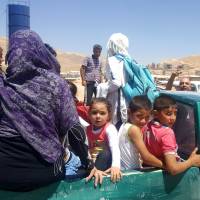 Syrian refugees arrive in Wadi Hamayyed, on the outskirts of Lebanon\'s northeastern border town of Arsal, to board buses bound for the northwestern Syrian town of Idlib on Aug. 2. | AFP-JIJI