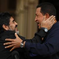 Argentina\'s Diego Armando Maradona (left) and then-Venezuelan President Hugo Chavez embrace upon Maradona\'s arrival to the Miraflores presidential palace in Caracas in 2010. On Monday, Maradona made a post on Facebook reading: \"We are Chavistas to the death.\" He also wrote that if current President Nicolas Maduro were to order it, he would \"dress as a soldier for a free Venezuela, to fight imperialism.\" | AP