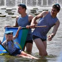 Russian military veterans cool off in a fountain as they celebrate Paratroopers\' Day at Gorky Park in Moscow on Wednesday. | AFP-JIJI