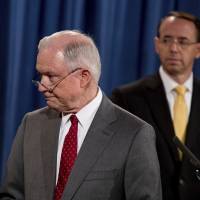 Deputy Attorney General Rod Rosenstein watches (at right) as Attorney General Jeff Sessions steps away from the podium during a news conference at the Justice Department in Washington Friday on leaks of classified material threatening national security. | AP