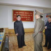 North Korean leader Kim Jong Un visits the Chemical Material Institute of the Academy of Defense Science in this photo released Wednesday. Posters for two apparently new missiles, the Pukguksong-3 (right) and an unknown Hwasong model are displayed on the walls. Even as tensions ease, North Korea releases photos indicating future missile types
