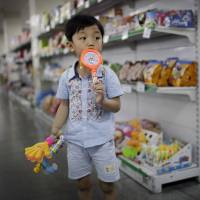 A North Korean boy holds a Doraemon toy drum with a candy-filled handle at the Potonggang department store in Pyongyang on June 19. The real revolution in North Korea is rise of consumer culture