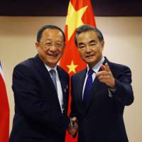 North Korean Foreign Minister Ri Yong Ho (left) is greeted by his Chinese counterpart, Wang Yi, prior to their bilateral meeting in the sidelines of a regional foreign ministers’ meeting Sunday in Manila. U.S., North Korean neighbors step up campaign of isolation