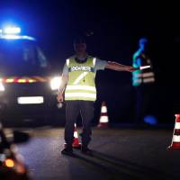 French gendarmes maintain a roadblock a certain distance from the scene where a car plowed into the outdoor terrace of a pizzeria, killing a young girl and injuring several other people, according to media reports in Sept-Sorts, east of Paris Monday. Possibly suicidal man held after plowing car into Paris-area pizzeria, killing girl, 13, injuring at least 12