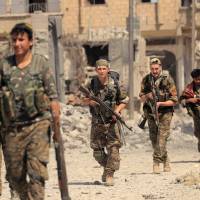 Members of the Syrian Democratic Forces advance toward Islamic State positions in Seif Al Dawla district of Raqqa, Syria, Wednesday. Tens of thousands of civilians feared trapped in Raqqa battle without access to aid